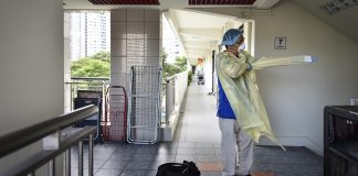 First (Responder) Family Fights Covid-19 Dr Tham Tuck Seng, 50, dons PPE before heading to a patient’s home, in July last year. Even after it was no longer required for doctors to wear PPE during house calls, Dr Tham continued to wear them to safeguard both the patient and himself.