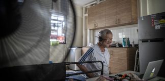 Singing to Keep Dementia at Bay Male senior watches a Zoom session from his rental flat in Singapore.