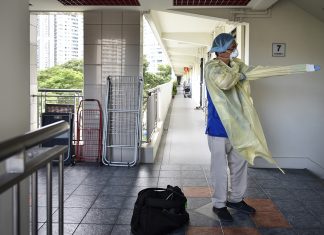 First (Responder) Family Fights Covid-19 Dr Tham Tuck Seng, 50, dons PPE before heading to a patient’s home, in July last year. Even after it was no longer required for doctors to wear PPE during house calls, Dr Tham continued to wear them to safeguard both the patient and himself.