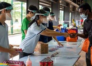 Teenagers, But Already Pros at Crisis Relief Peace and Daniel Lim, 18 and 15, distribute items to migrant workers