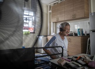 Singing to Keep Dementia at Bay Male senior watches a Zoom session from his rental flat in Singapore.