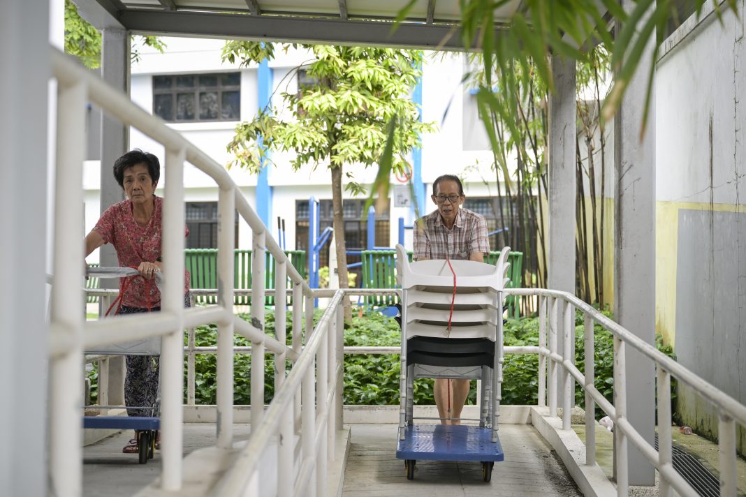 Mr Ang Lye Hock and other volunteers, known as micro-jobbers, move chairs from the Thye Hua Kwan office to a pavilion where seniors exercise. Through the micro-jobs scheme funded by the Tote Board, these micro-jobbers are paid a small fee per task.